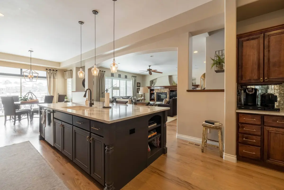 An open plan kitchen with a large island looking through to a family room